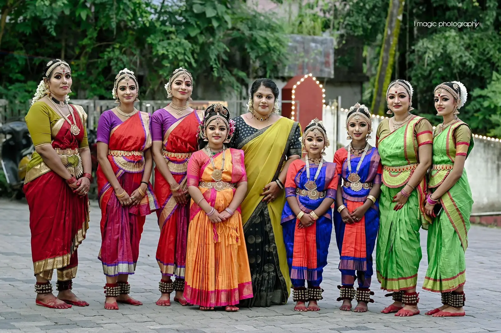 3. A woman in traditional Indian dress, holding a flower, stands with a group of teachers, all smiling in a sunny location.</p>
<p>
